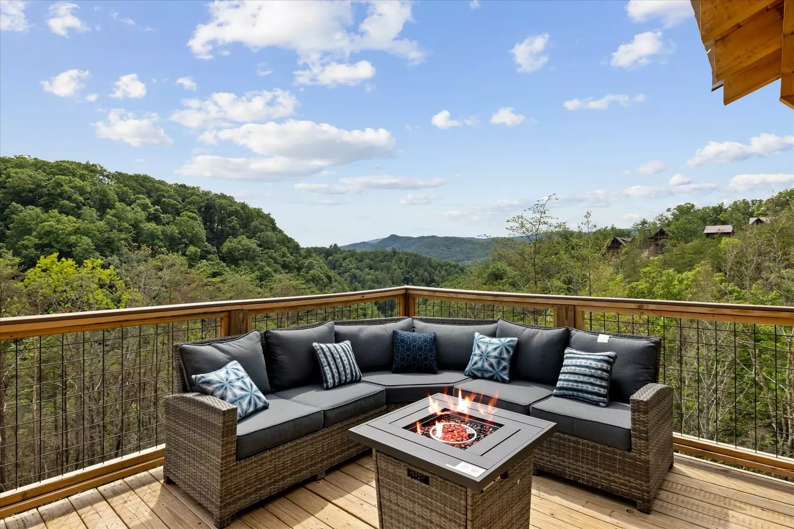 fire pit and sofa on deck of cabin with a mountain view