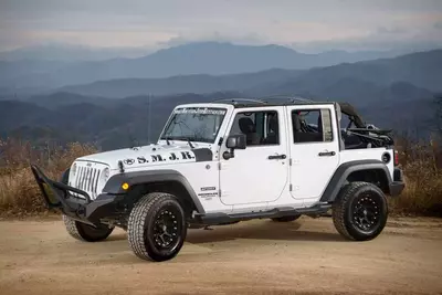 white jeep in front of the mountains