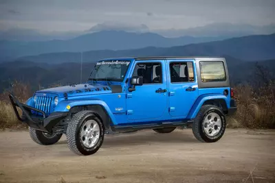 blue jeep in front of the mountains