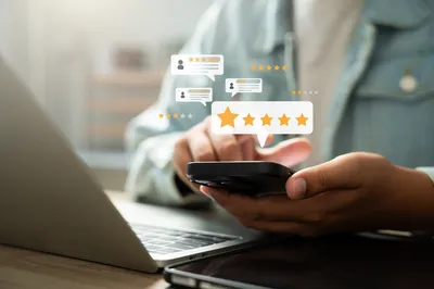 Person reading reviews on phone and laptop